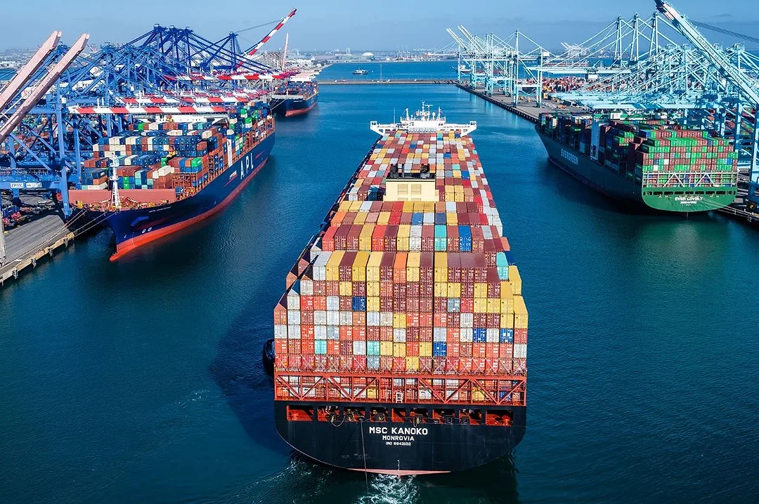 Container ship loaded at a busy port terminal